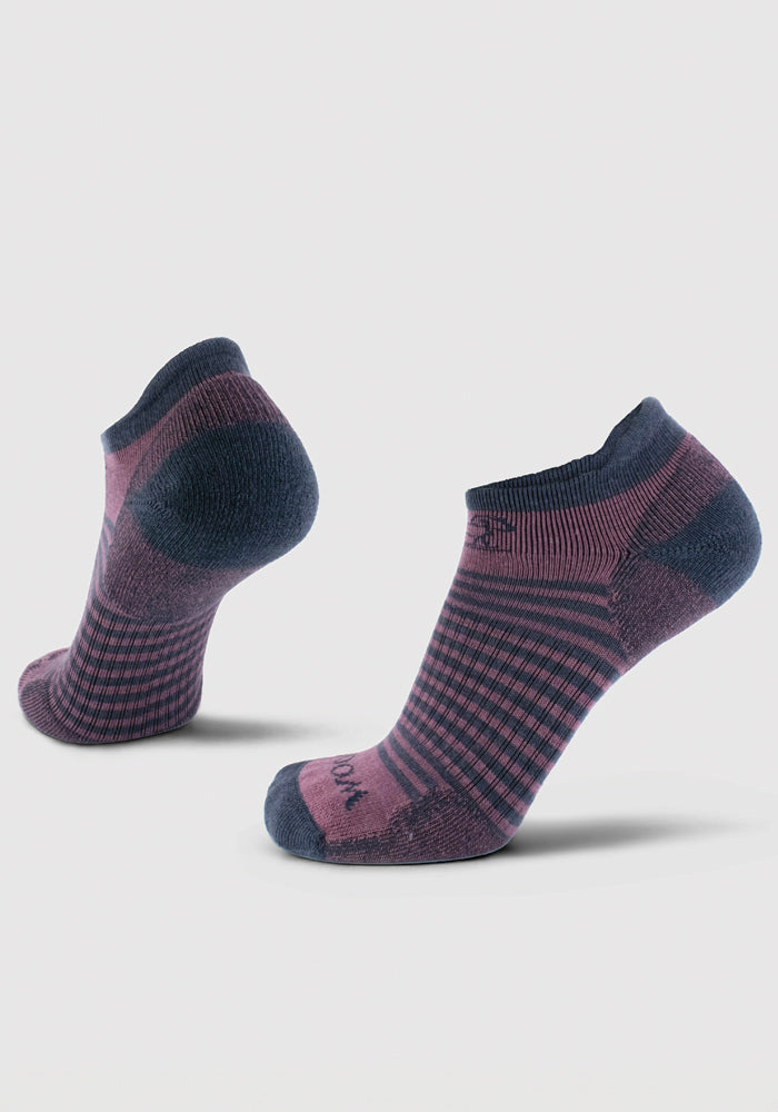 The Amelia No Show Tab Lightweight Socks by Woolx come in a pair, presented on a white background. These socks showcase a checkered pattern in shades of purple and dark blue with solid-colored toes and heels. Made from Merino wool, one sock stands upright while the other leans backward.