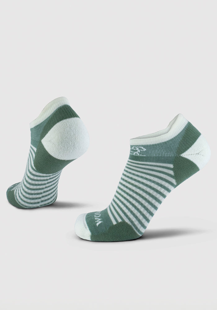 A pair of Amelia No Show Tab Lightweight Socks in Sparrow Green, from Woolx, is showcased against a plain background. These socks are crafted from soft merino wool and feature moisture-wicking properties with dark and light green stripes, complemented by white accents on the heels and toes for an odor-free experience all day.