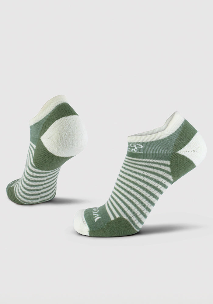 The Amelia No Show Tab Lightweight Socks in Sparrow Green by Woolx are displayed with one sock upright showing the heel, and the other slightly tilted to highlight the toe and sole. These moisture-wicking socks have cushioned heels and toes, ensuring your feet stay dry and comfortable all day long.