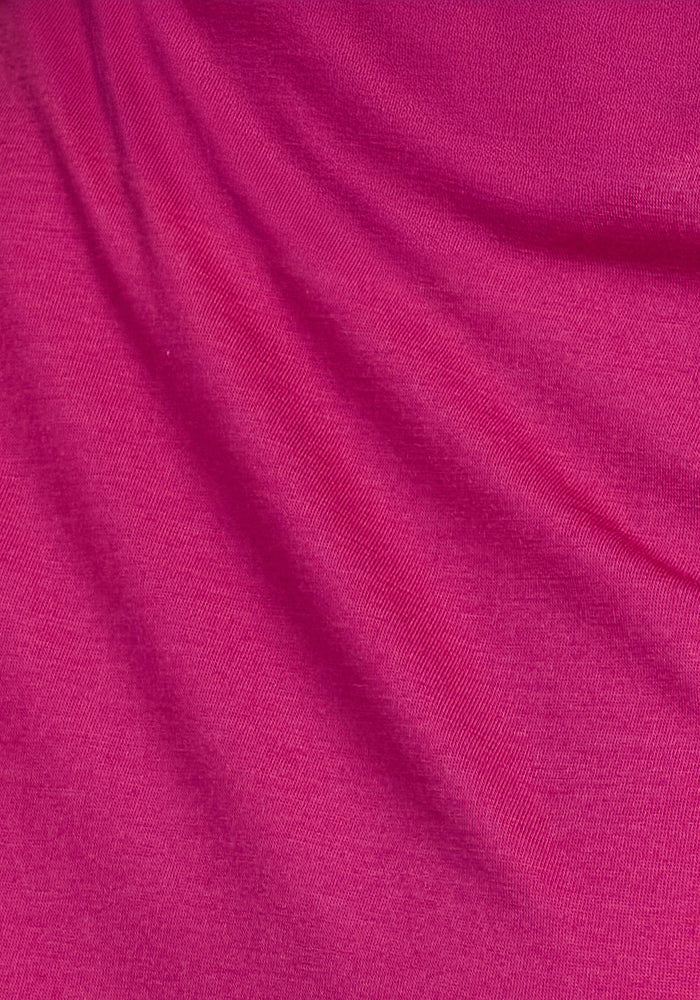 Close-up of the Liza Crew Neck Tee in Berry Punch by Woolx, highlighting its vibrant pink color, soft folds, and smooth texture that showcase the performance benefits of its lightweight material.