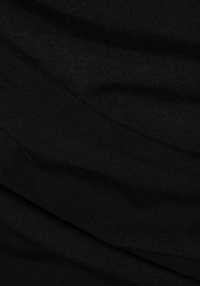 Close-up of Stella Petite - Black from Woolx, featuring black DuraLite fabric with a slightly textured surface, displaying gentle folds and subtle shadows. The material appears smooth, with a matte finish.