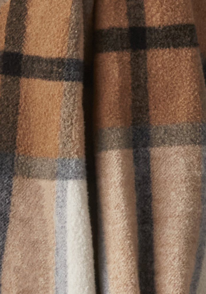 Close-up of the Sutton Shacket by Woolx in a Camel Plaid pattern, showcasing intersecting lines in shades of brown, beige, blue, and black. Perfect for winter wear, the soft and warm fabric evokes a cozy feel.