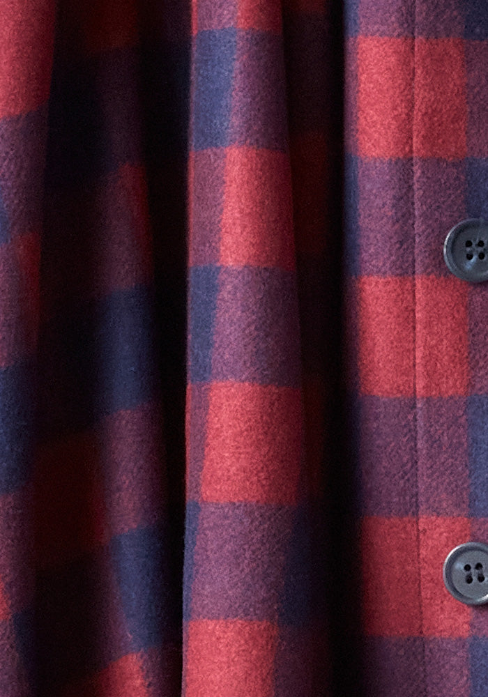 This close-up highlights the Burlington Jacket - Cranberry Navy Checkered from Woolx, showcasing its ultra-heavyweight super soft boucle Merino fabric with dark buttons. The wool-like material feels warm, indicating it's designed as a cozy coat or jacket crafted from fine Australian Merino Wool.