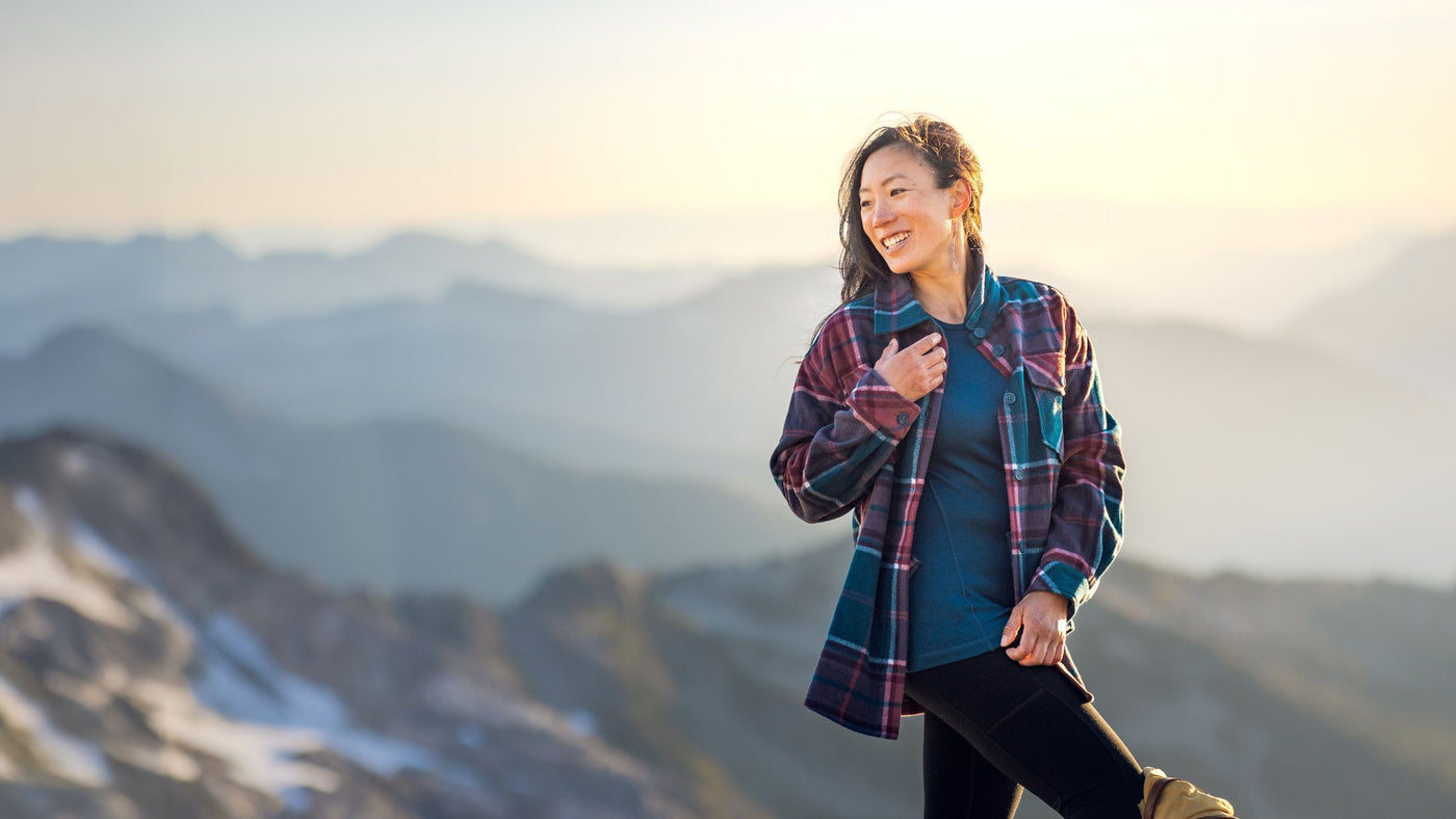 Model standing on mountain wearing heavy baselayers and Sawyer shacket