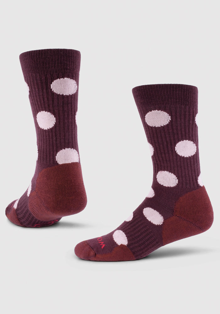 A pair of maroon Dotalicious Light Cushion Crew Socks by Woolx, featuring the Wild Ginger Dot pattern with large pink polka dots, are displayed upright. They are shown in both front and side views against a plain white background. These stylish socks also boast odor-resistant properties for lasting freshness.