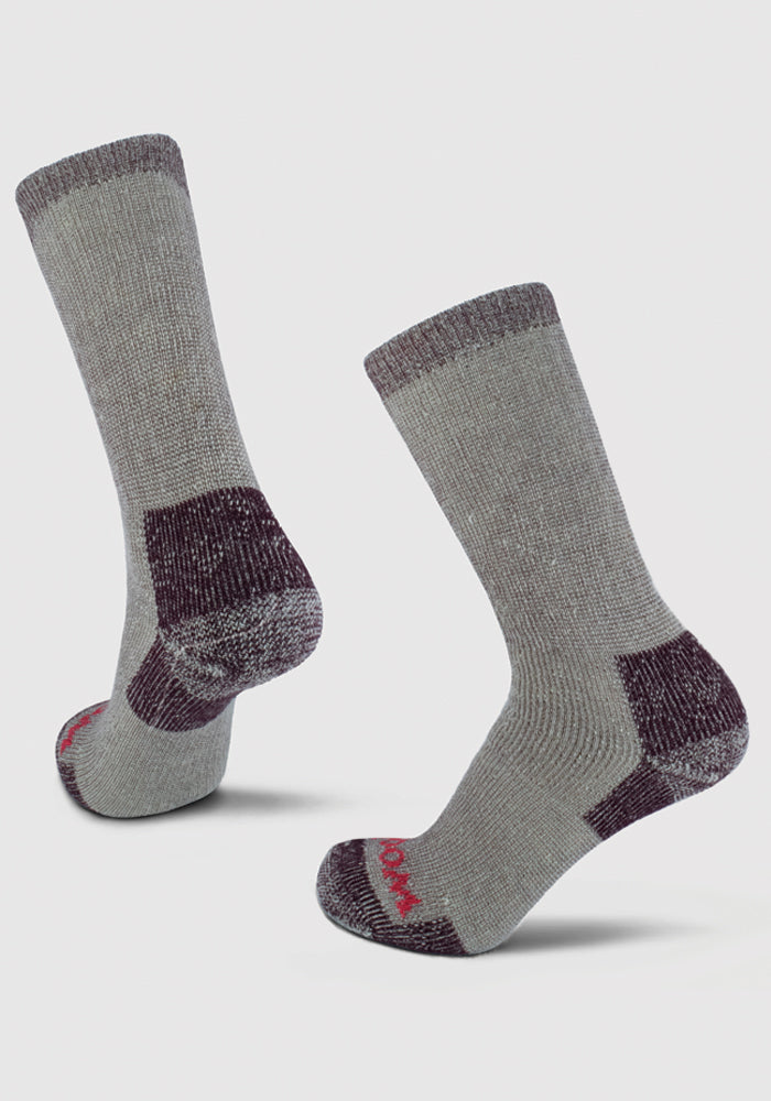 A pair of Windsor Wine Extreme Full Cushion Crew Socks by Woolx, made from merino wool for exceptional warmth, showcases darker gray heels, toes, and cuffs standing upright on a light gray background. One sock is accented with striking red text near the toe area.