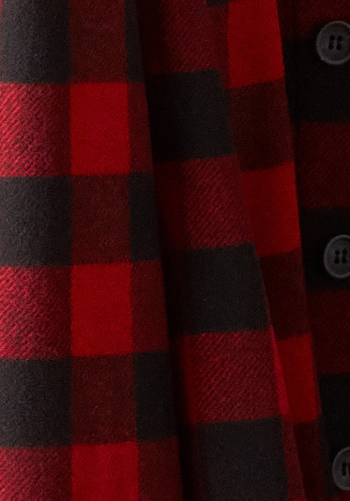 Close-up of an ultra-heavyweight red and black plaid fabric with large checks. The material, crafted from super soft Australian Merino wool by Woolx, gives off a warm and cozy vibe. Four black buttons run vertically along the edge, hinting that it could belong to the Burlington Jacket - Red Black Plaid.