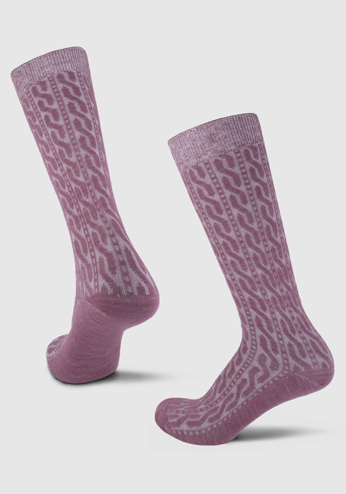 A pair of Woolx Tilly Cable Knit Socks in Wild Ginger, featuring an intricate chain link pattern in a lighter shade. The socks are displayed on a white background, with one sock upright and the other tilted slightly forward.