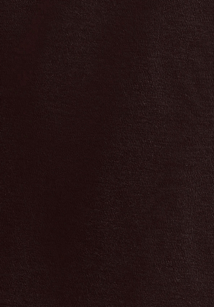 A close-up image of the Blair Tunic in French Roast by Woolx showcases its dark brown textured fabric. The material appears smooth with a subtle, finely woven pattern, and the lighting highlights the uniformity and consistency of its texture.