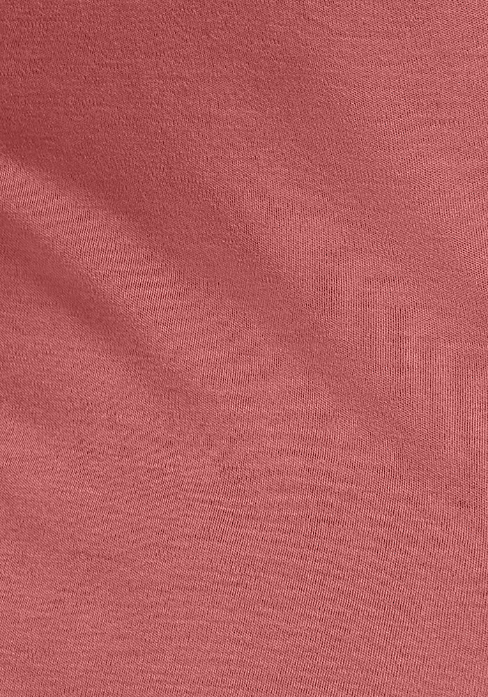 A close-up view of the red Kenzie Scoop Neck from Woolx, made with Merino wool that has a smooth yet slightly textured surface. The lighting creates subtle shadows and highlights, showcasing the weave and structure of this versatile material, making it perfect for a business casual top.