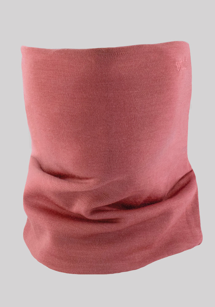 A close-up image of a Woolx Neck Gaiter in pink, isolated on a plain gray background. The fabric appears soft and slightly folded around the bottom, showcasing a smooth and seamless texture perfect for outdoor activities.