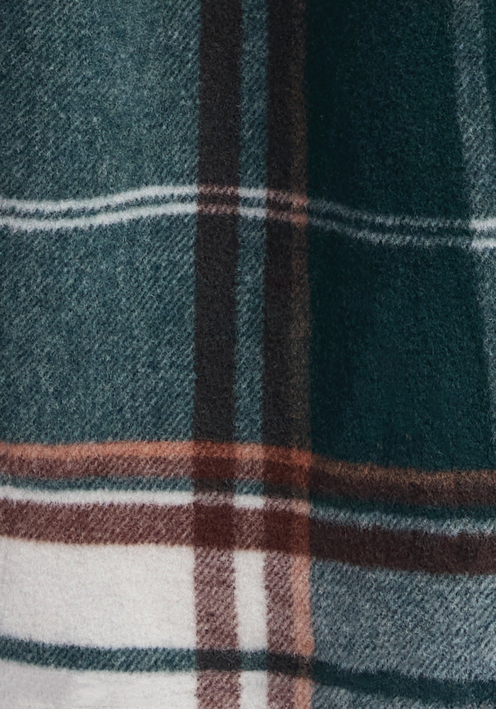 Close-up of a green, white, and brown plaid fabric from the Sawyer Shacket by Woolx. The pattern includes large vertical and horizontal stripes intersecting to form a classic checkered design. The texture of the Merino wool fabric appears soft and woolly.