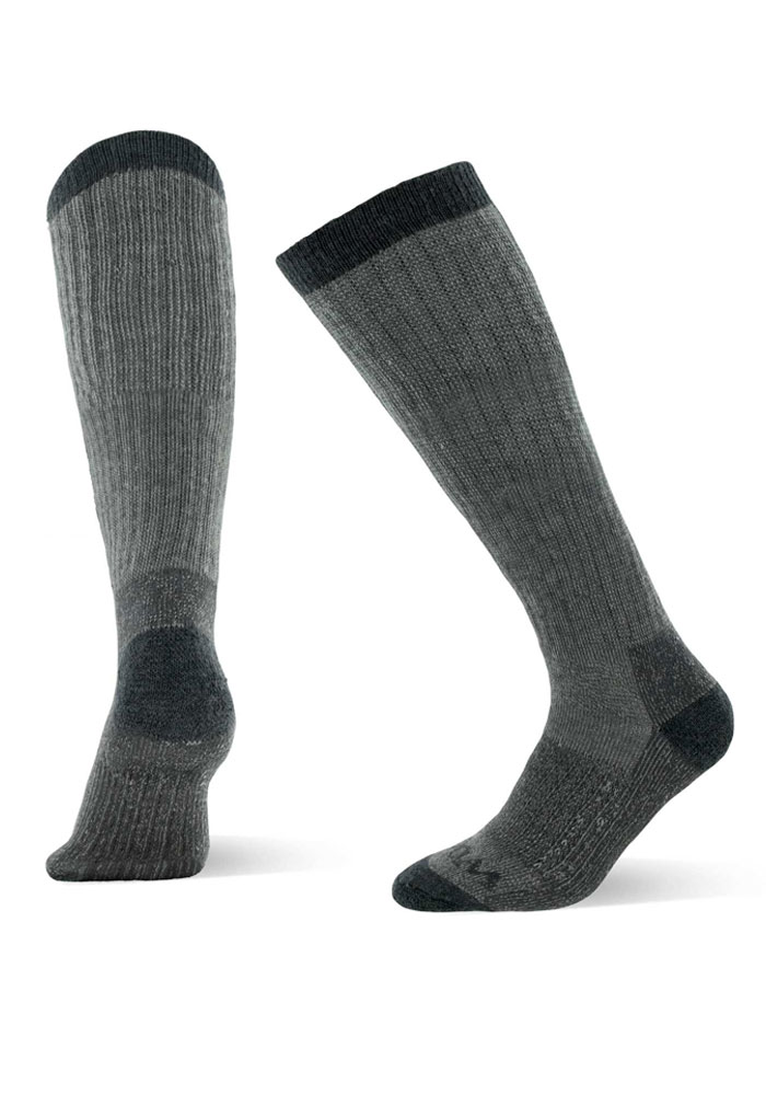 A pair of "Extreme Full Cushion Over The Calf - Charcoal Heather" socks from Woolx, featuring a tall charcoal heather design with darker accents on the cuffs, heels, and toes. Ideal for cold-weather insulation, the socks are showcased in various angles: one positioned upright and the other slightly bent to highlight the heel. They have a ribbed texture for added warmth.