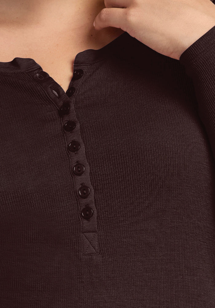 Close-up of a person wearing the Reese Ribbed Henley in French Roast by Woolx, made from soft Merino wool. The long sleeves and button-front placket with multiple buttons enhance its classic appeal. The person's hand is partially visible near the collar, adding to the intimate capture.