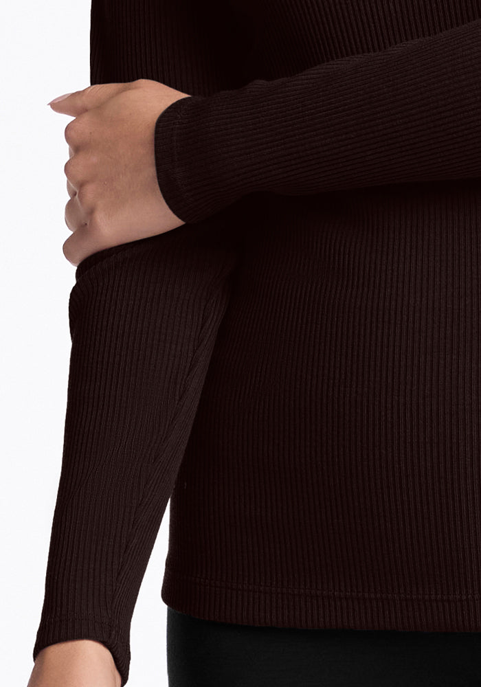 A person confidently wearing the luxurious Hadley Ribbed Crew in French Roast, with arms crossed over their chest against a plain white background, showcasing the elegance of its dark brown Merino Wool by Woolx.