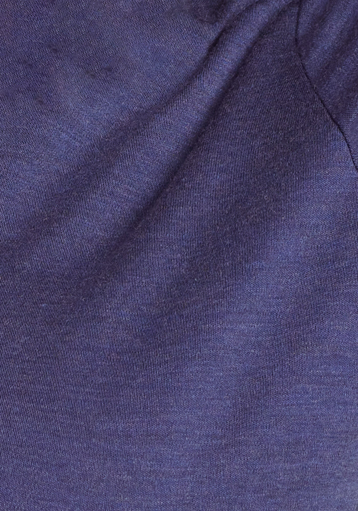 Close-up image of the dark blue, textured fabric with slight creases and folds, suggesting it may be from the Hannah Long Sleeve Top by Woolx. The fabric appears to be of medium weight with a soft, smooth surface, offering breathable and moisture-wicking properties.