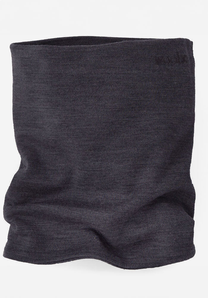 A Woolx Neck Gaiter in dark grey fabric is displayed against a plain white background. Ideal for outdoor activities, this gaiter looks soft and gently wrinkled, featuring a subtle texture that suggests Merino comfort. The brand name "Woolx" is faintly visible in black stitching near the top right edge.