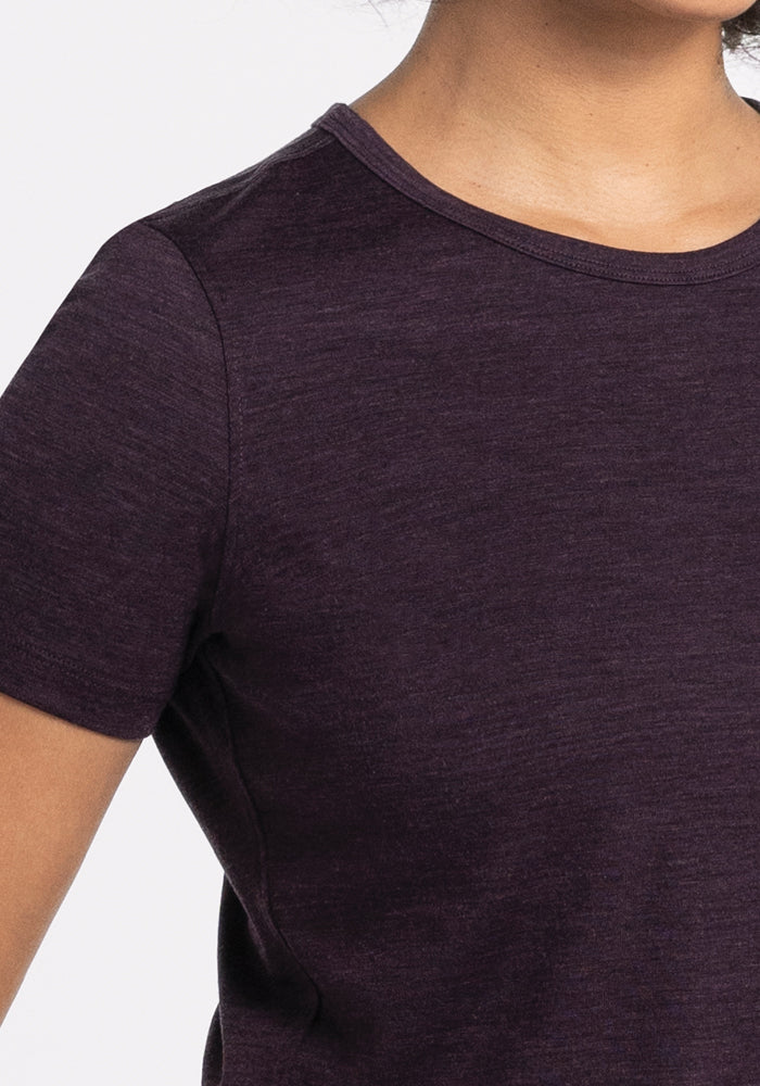 A person wearing the Liza Crew Neck Tee in Deep Plum by Woolx stands against a plain background. The upper body is visible, highlighting the short-sleeve design and lightweight fabric.