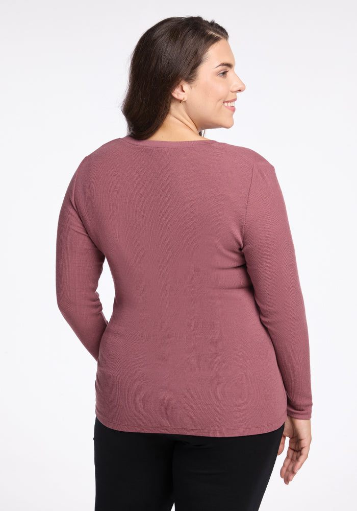 A person with long dark hair is shown from the back, wearing the Reese Ribbed Henley by Woolx in Wild Ginger and black pants, set against a plain white background.