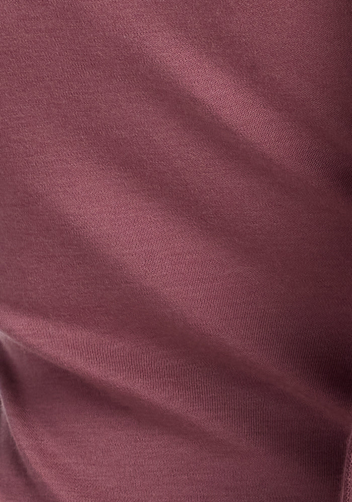 Close-up of a maroon-colored fabric with a smooth, slightly ribbed texture. The Merino wool used in the Woolx Kenzie Scoop Neck appears to be soft and lightweight, with subtle shadows and highlights creating a sense of depth and dimension. Perfect for crafting a versatile top that transitions effortlessly into business casual attire.