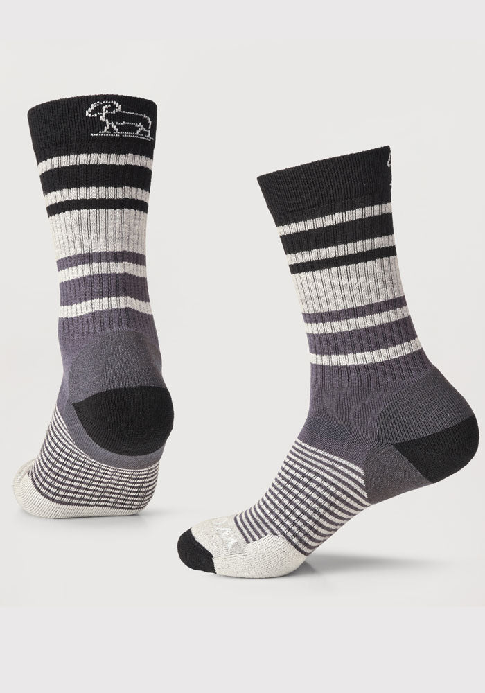 The Everyday Light Cushion Crew Socks from Woolx, available as a stocking stuffer final sale deal, come in a stormy stripe color with a small white sheep design on top. These durable socks are crafted from odor-resistant merino wool and include ribbed cuffs, a reinforced heel and toe, and various stripe patterns throughout the body, all set against a plain background.