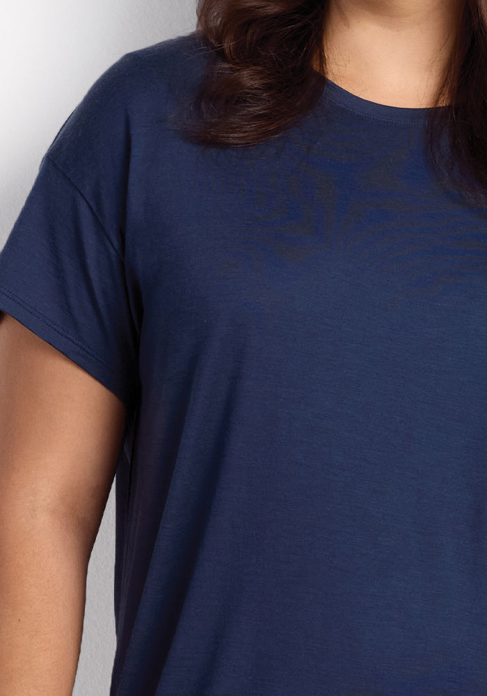 A person wearing the Billie Lounge Tee in Starry Night by Woolx. The focus is on the upper body, emphasizing its simple design and short sleeves, ideal for hot sleepers. The person's hair is partially visible.